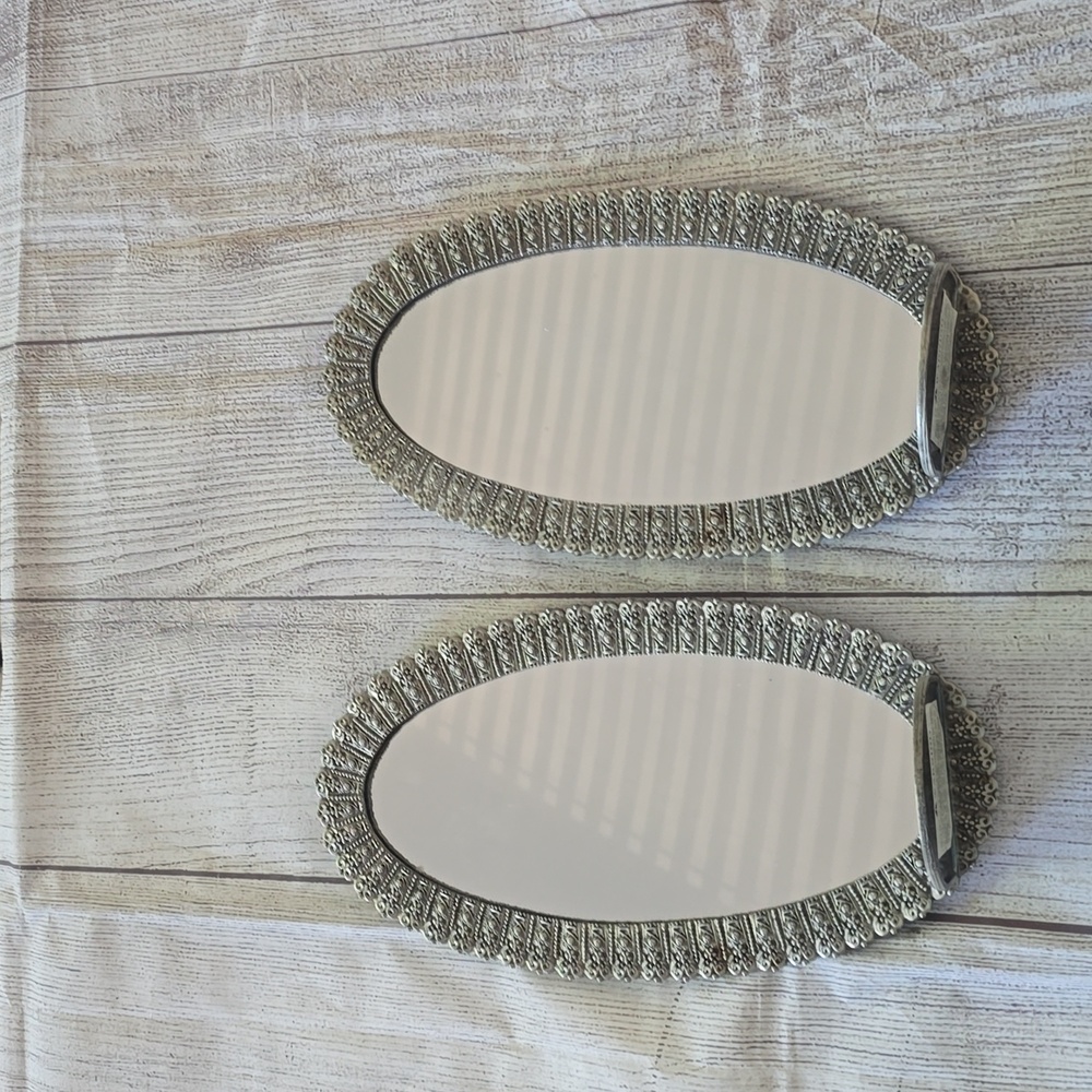 Set of 2 new silver, oval shaped ornate mirror sconces.